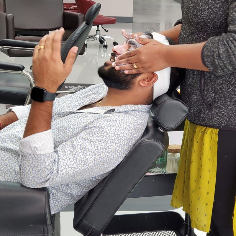 A man receiving a facial treatment in a salon chair