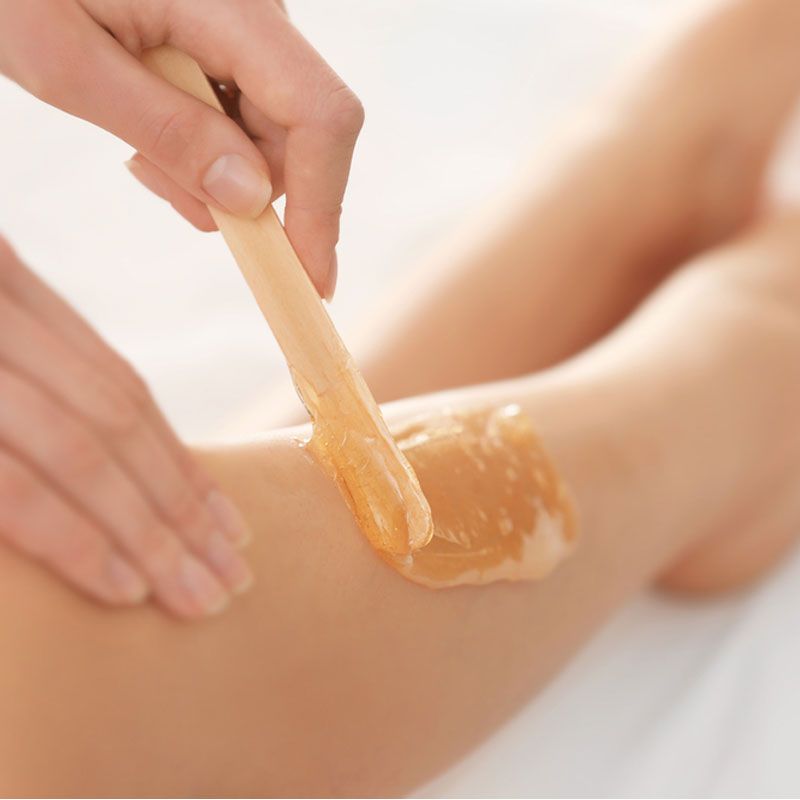 Wax being applied to an arm during a waxing service